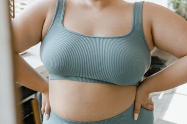 Considering Breast Reduction (Reduction Mammaplasty) A busty woman looks in the mirror and contemplates breast reduction surgery (reduction mammaplasty)